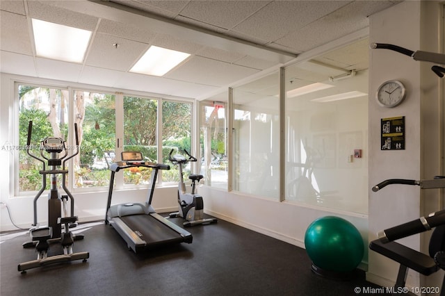 workout area featuring a wealth of natural light, baseboards, and a paneled ceiling