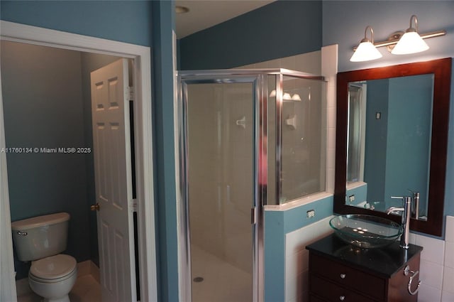 full bath with vanity, a shower stall, and toilet