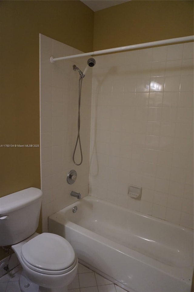 bathroom with tile patterned floors, shower / washtub combination, and toilet