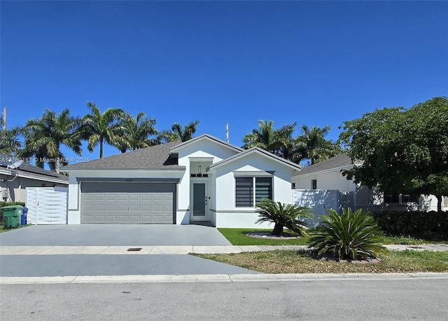 view of front of house featuring stucco siding, driveway, an attached garage, and a shingled roof