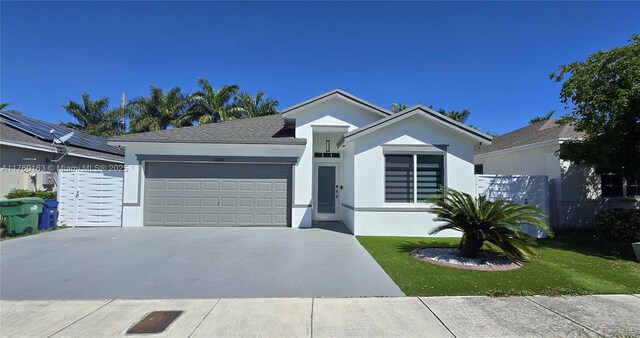 ranch-style home with stucco siding, a front yard, concrete driveway, and an attached garage