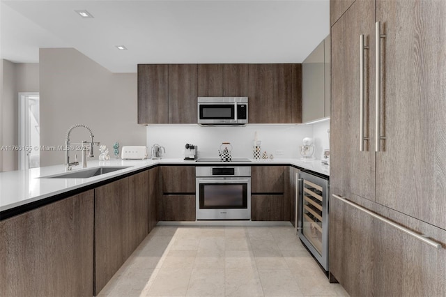 68 SE 6th St Unit 1404, Miami, FL 33131 - kitchen with a sink, wine cooler, light countertops, stainless steel appliances, and modern cabinets