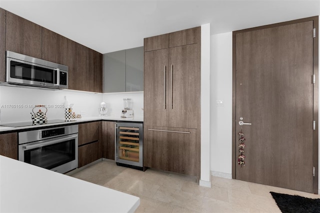 68 SE 6th St Unit 1404, Miami, FL 33131 - kitchen with beverage cooler, stainless steel appliances, light countertops, dark brown cabinets, and modern cabinets