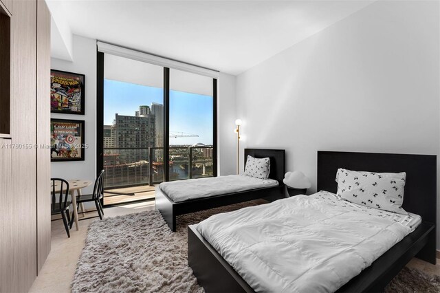 68 SE 6th St Unit 1404, Miami, FL 33131 - bedroom with a wall of windows, light colored carpet, and a city view