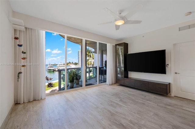 unfurnished living room with visible vents, wood finished floors, and a ceiling fan