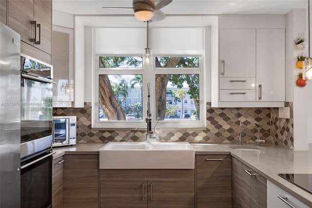 kitchen featuring black appliances, modern cabinets, and a sink