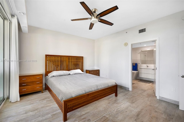 bedroom with visible vents, light wood-style flooring, a ceiling fan, ensuite bath, and baseboards