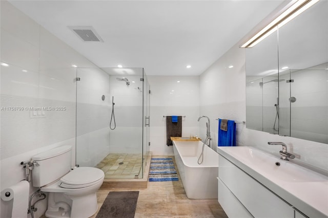 full bathroom featuring vanity, toilet, tile walls, and a shower stall