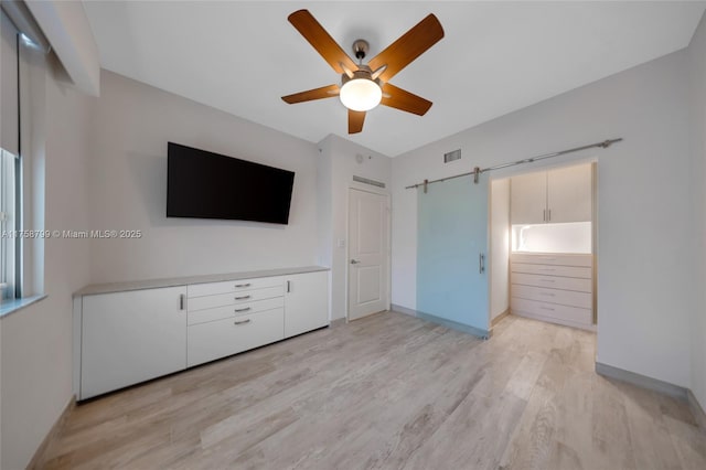 unfurnished bedroom with a ceiling fan, light wood-style floors, visible vents, and baseboards