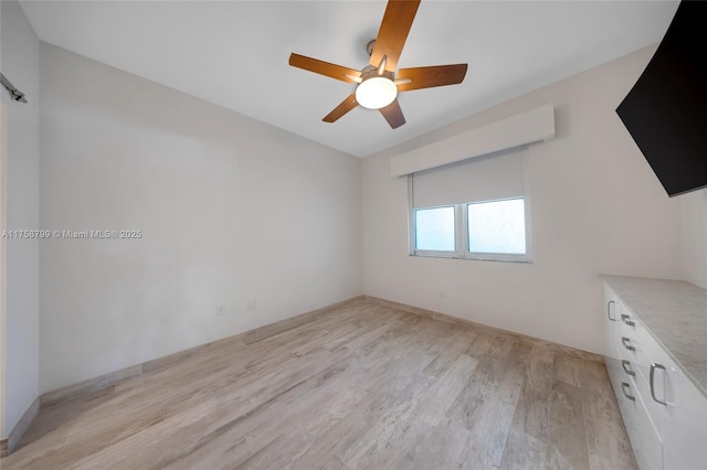 empty room featuring ceiling fan and light wood-style flooring