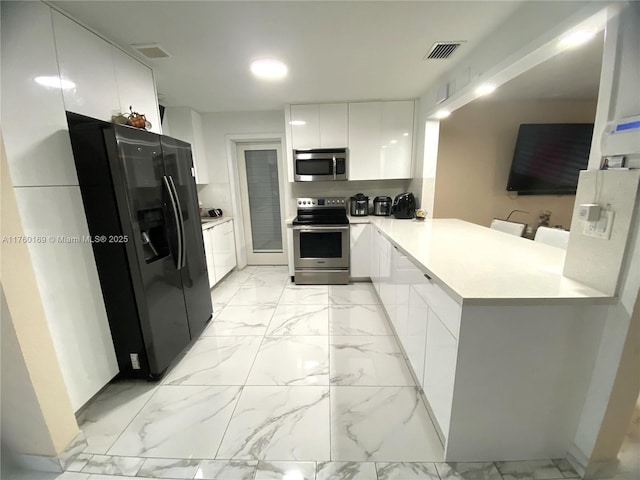 kitchen featuring white cabinets, marble finish floor, appliances with stainless steel finishes, and modern cabinets