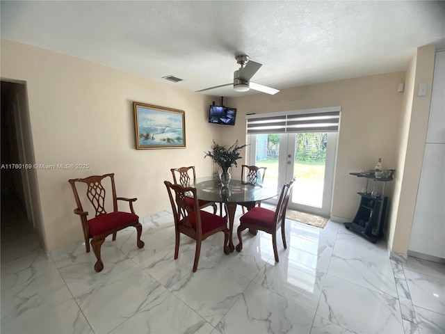 dining room featuring visible vents, marble finish floor, a textured ceiling, french doors, and ceiling fan