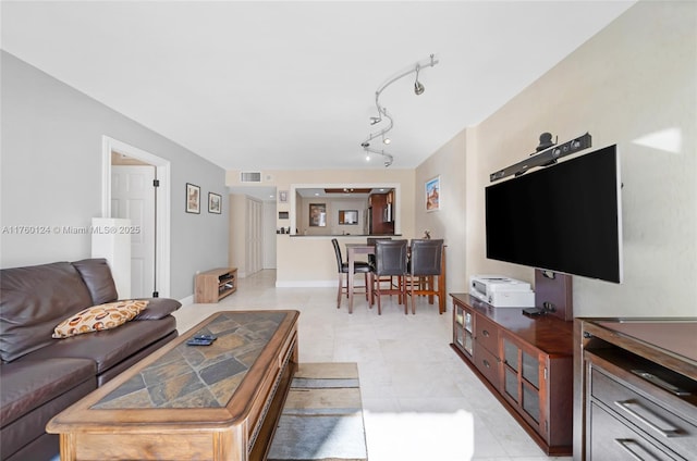 living room with visible vents, rail lighting, and baseboards