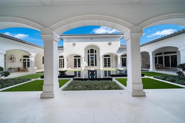 view of property's community featuring a patio area and a lawn