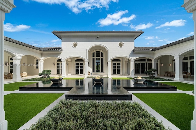 view of home's community with a lawn and a patio area