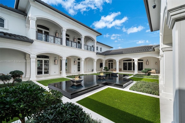 rear view of property featuring stucco siding, a patio, and a balcony