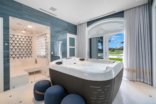 bathroom with tile patterned floors, tile walls, and a shower stall