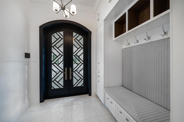 mudroom with arched walkways, french doors, baseboards, and an inviting chandelier