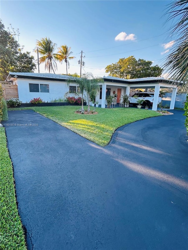 single story home with a carport and a front lawn