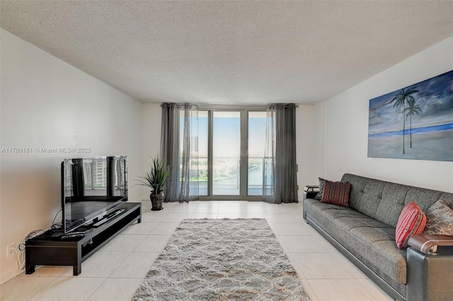 tiled living area featuring a textured ceiling and a wall of windows