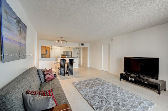 living area with light tile patterned floors and a textured ceiling