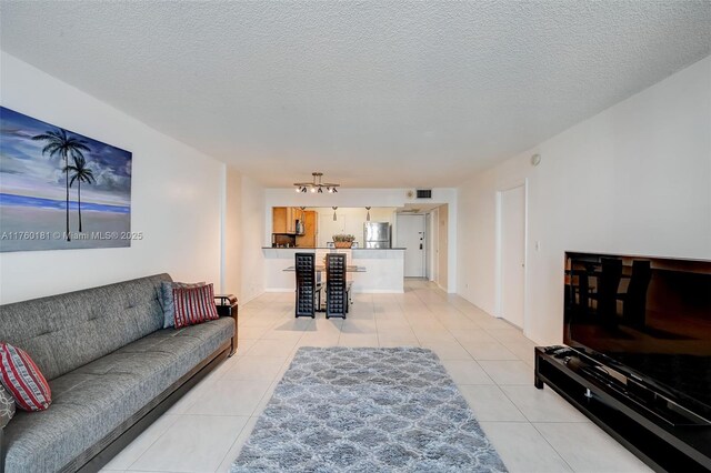 living room with light tile patterned floors, visible vents, and a textured ceiling