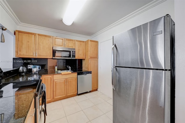 kitchen with a sink, appliances with stainless steel finishes, crown molding, and light tile patterned floors