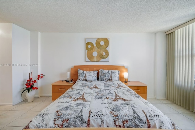 bedroom with light tile patterned floors, a textured ceiling, and baseboards