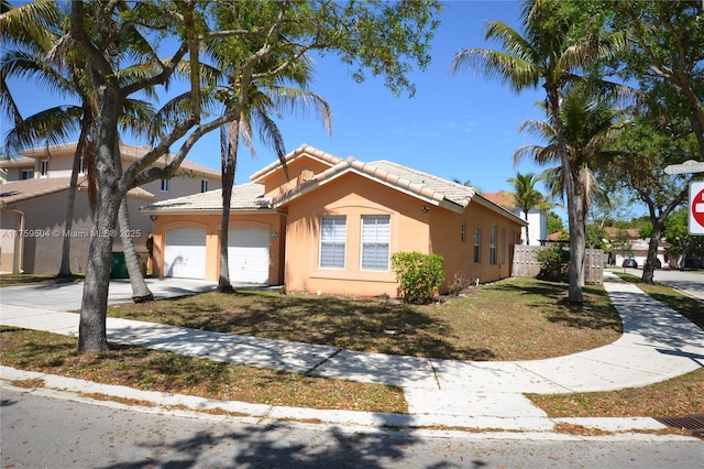 view of front of home with fence, driveway, an attached garage, stucco siding, and a tile roof