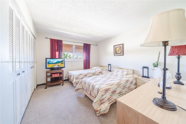 bedroom featuring light carpet and a textured ceiling