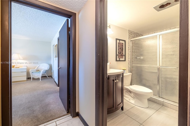 bathroom with a shower stall, a textured ceiling, vanity, and toilet