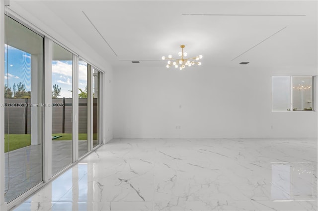 empty room featuring a chandelier and marble finish floor