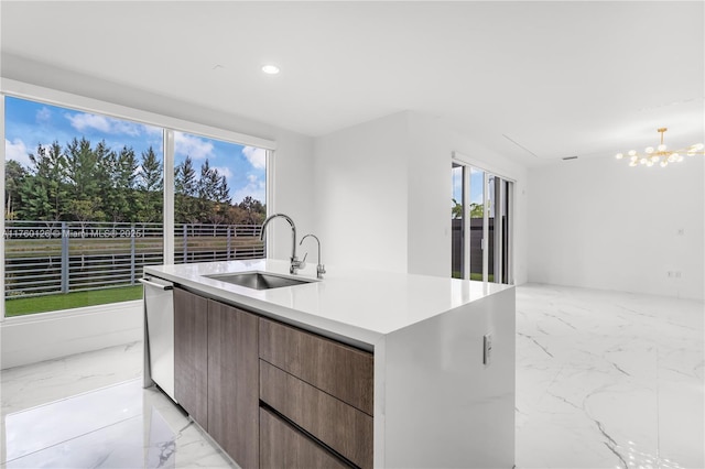 kitchen with a sink, plenty of natural light, marble finish floor, modern cabinets, and stainless steel dishwasher