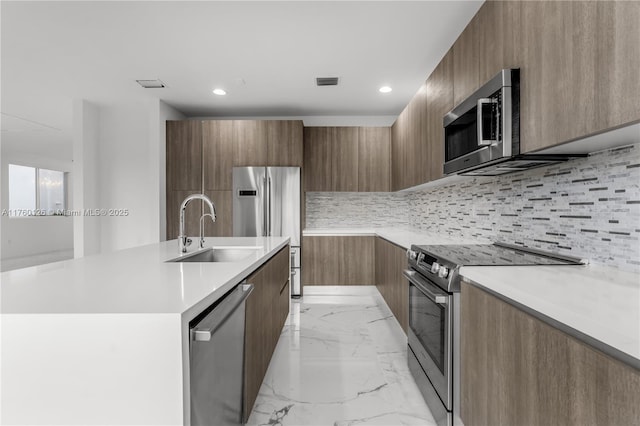 kitchen with visible vents, marble finish floor, modern cabinets, a sink, and appliances with stainless steel finishes