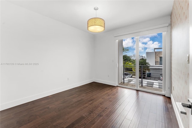 unfurnished room featuring dark wood-style floors and baseboards