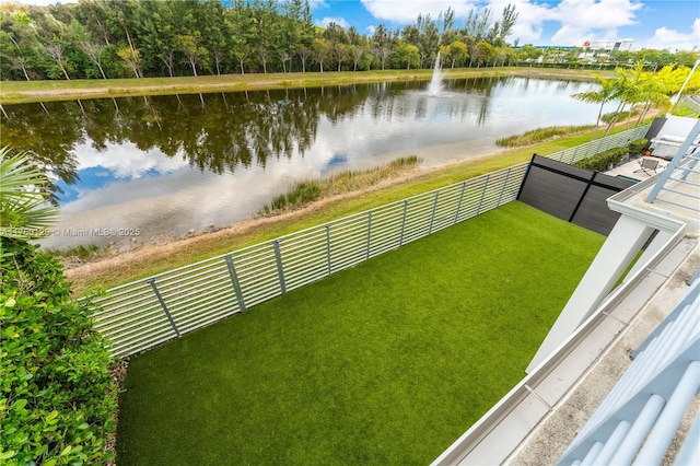 exterior space featuring a fenced backyard and a water view