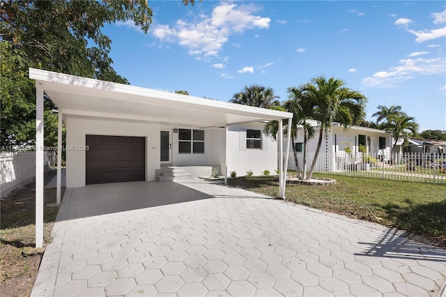 ranch-style home with a garage, stucco siding, driveway, and fence