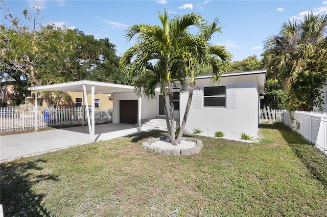 view of front of house with stucco siding, driveway, a front lawn, fence, and a carport