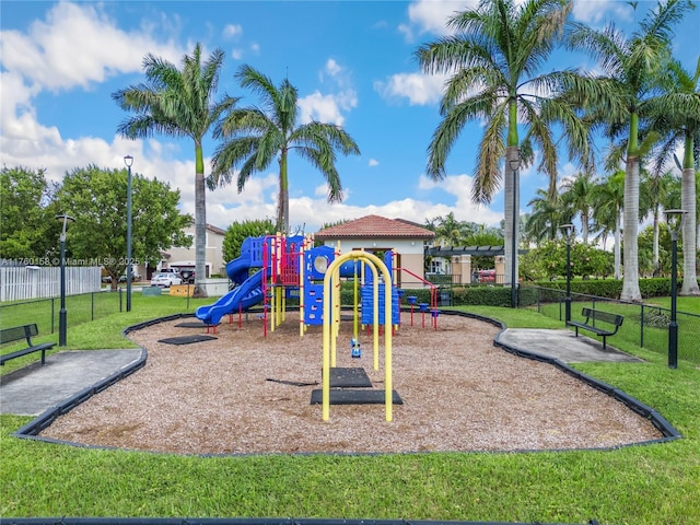 community playground with a yard and fence