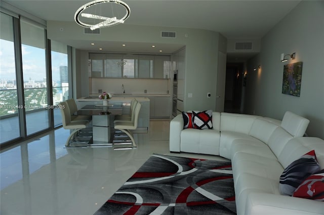 living area featuring a view of city, floor to ceiling windows, visible vents, and a chandelier