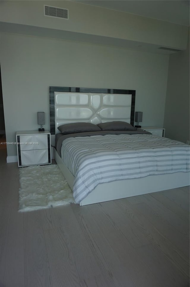 bedroom featuring visible vents and wood finished floors