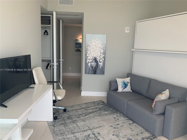 living room featuring visible vents, baseboards, and wood finished floors