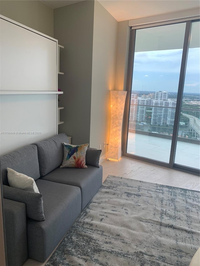 living area with a wall of windows and wood finished floors