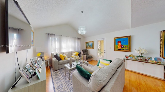 living room with lofted ceiling, wood finished floors, and a textured ceiling