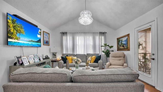 living room with a textured ceiling, wood finished floors, and vaulted ceiling