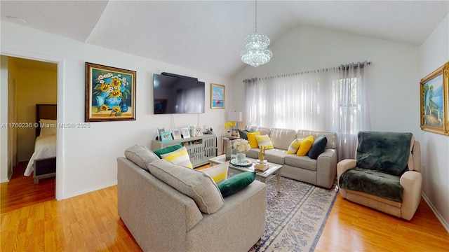 living room featuring baseboards, a notable chandelier, wood finished floors, and vaulted ceiling