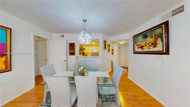 dining room featuring visible vents, baseboards, and light wood-style floors