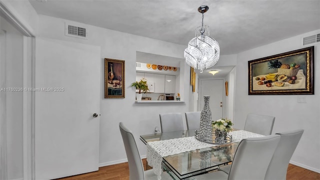 dining room with visible vents, baseboards, and wood finished floors