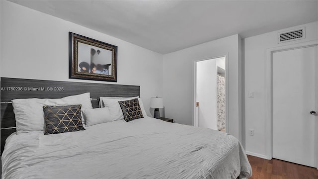 bedroom with visible vents, baseboards, and dark wood-type flooring