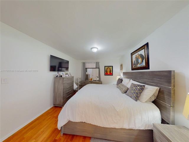 bedroom featuring wood finished floors and baseboards